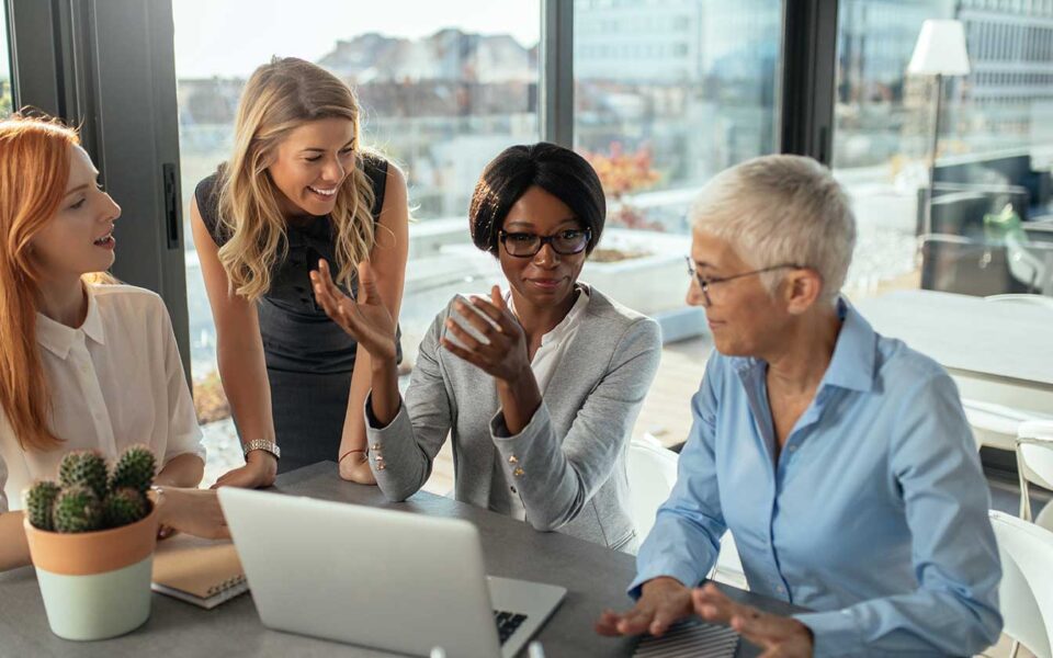 Diverse group of women by computer