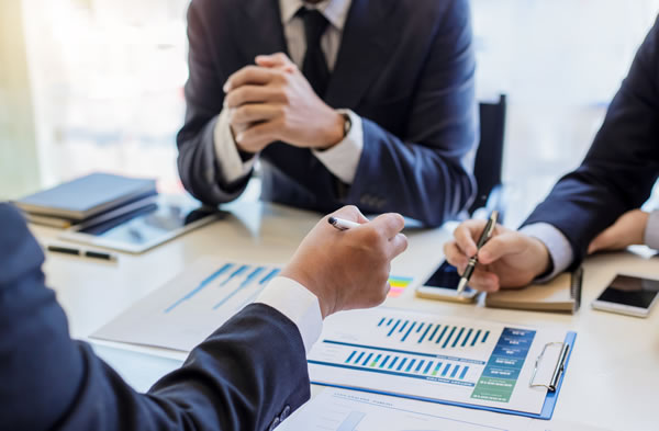 business people sitting at table with charts