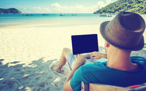 man on beach with laptop